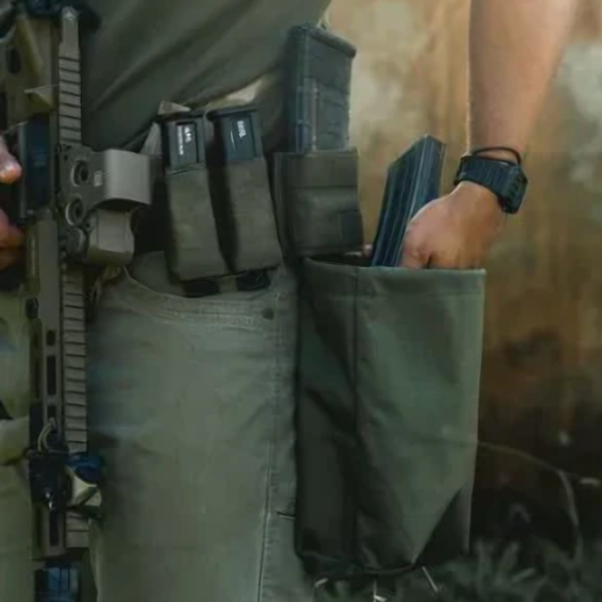 Person wearing a tactical belt with magazines, holster, and an open pouch during outdoor gear carry.